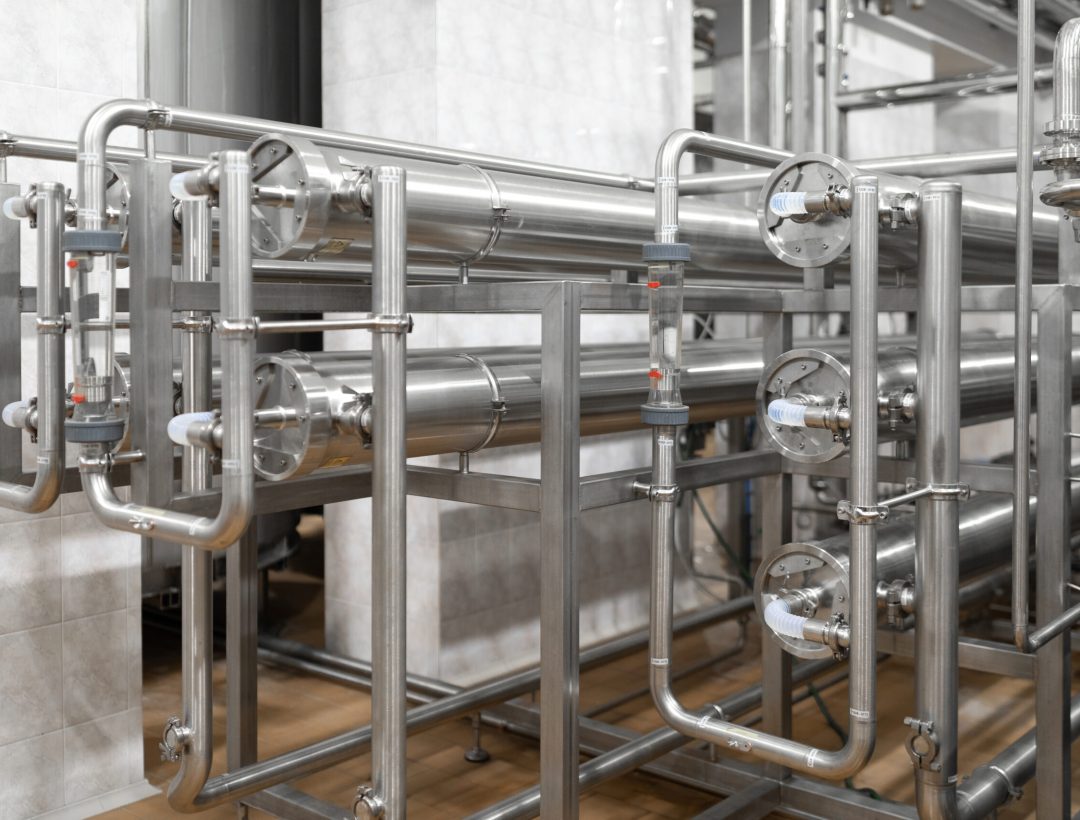 Modern brewery factory interior. pipe lines and other equipment tool in plant workshop. Industrial background. Metal pipes close-up. Industrial plant inside view. Maze of pipes background